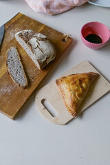 Freshly cut homemade rye bread with apple pastry on wooden cutting board on kitchen table