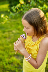 Happy girl with braces eating italian ice cream cone smiling while resting in park on summer day