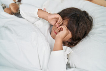 Adorable hispanic girl lying on bed sleeping at bedroom