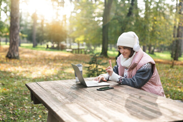 Woman in the park with a laptop.