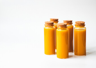 Fototapeta na wymiar Homemade Immune Boosting Turmeric Ginger Citrus Shots. Anti-Inflammatory Healthy Drink. Still Life on white background, top view. Natural Immunity System Booster