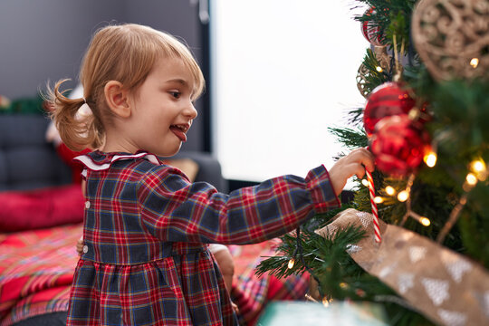 Adorable caucasian girl smiling confident decorating christmas tree at home