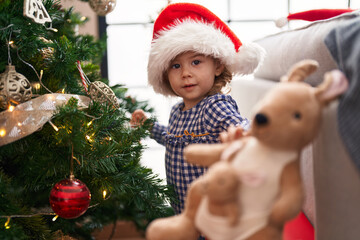Adorable hispanic girl smiling confident decorating christmas tree at home