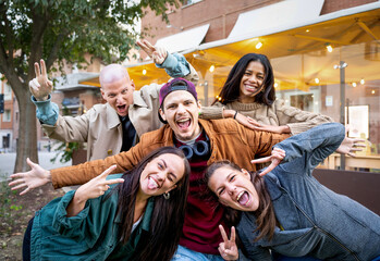 Friends group having fun outside - Happy people taking picture screaming at camera - .Young crazy guys together at city center - Community and friendship - Focus on central man