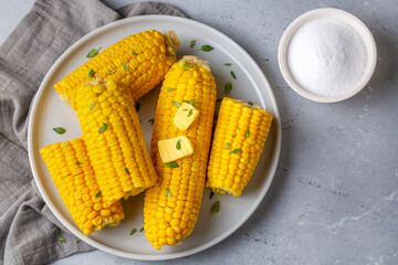 Cooked corn on the cob served with salt and butter, simple summer dish