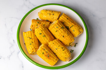 Cooked corn on the cob served with salt and butter, simple summer dish