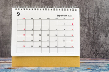 The September 2023 Monthly desk calendar for 2023 year on wooden table.