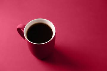 Obraz na płótnie Canvas Coffee in viva magenta cup on monochrome background. Close up. Copy space. Trending color of 2023 - Viva Magenta.
