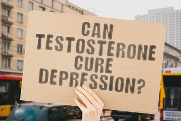 The question " Can testosterone cure depression? " is on a banner in men's hands with blurred background. Stress. Bodybuilding. Metabolism. Deficiency. Diagnosis. Molecular. Mass. Research. Sex