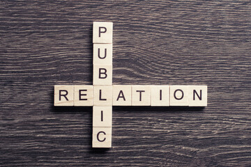 Public Relation crossword on office table collected of wooden cubes