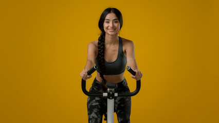 Indian slim happy smiling sporty woman female lady athletic girl cyclist biking flexing cycling...