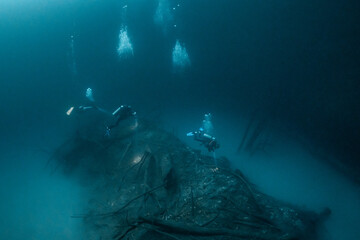 cave diver instructor leading a group of divers in a mexican cenote underwater