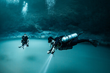 cave diver instructor leading a group of divers in a mexican cenote underwater - obrazy, fototapety, plakaty