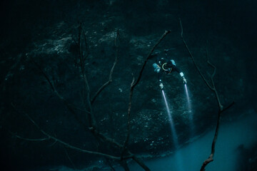 cave diver instructor leading a group of divers in a mexican cenote underwater