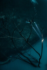cave diver instructor leading a group of divers in a mexican cenote underwater