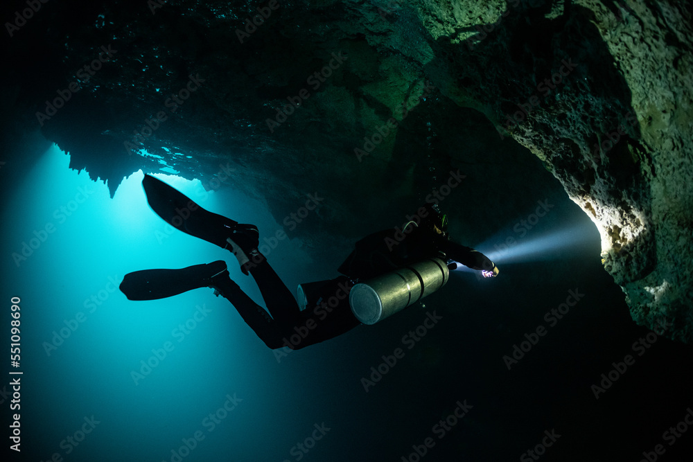 Wall mural cave diver instructor leading a group of divers in a mexican cenote underwater