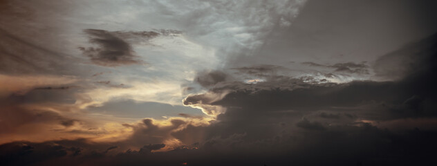 Obraz premium The sun's rays passing through the clouds and shining form an interesting light pattern against the sky. Panoramic shot, Space for text, Selective focus.