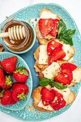 Bruschetta Sandwich with sstrawberries, cheese camembert nuts and honey basil, served as an appetizer