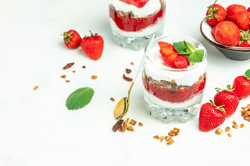 Parfait Greek yogurt with fresh strawberry and granola on a wooden board. gluten free diet, Healthy breakfast. banner, menu, recipe place for text, top view