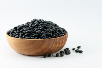 Fototapeta na wymiar Black beans in a wooden bowl placed on a white floor.