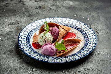 Tasty appetizing ice cream in waffle cones with mint on dark background. Top View