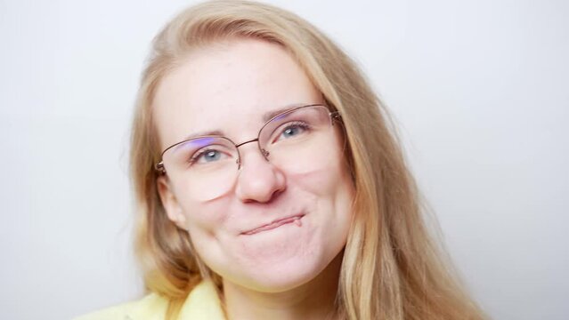 Portrait of a young preety cheerful, thoughtful woman with a playful look. European beautiful blonde woman in glasses. White background stock video