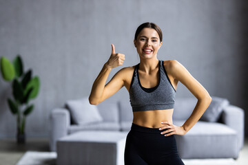 Fototapeta na wymiar Photo of cute charming young woman wear sport outfit smiling showing okey sign indoors home house