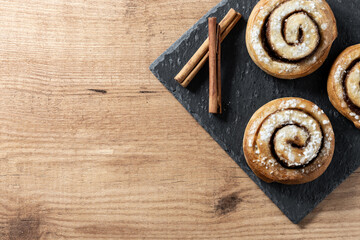 Cinnamon rolls buns on wooden table. Kanelbulle Swedish dessert. Copy space
