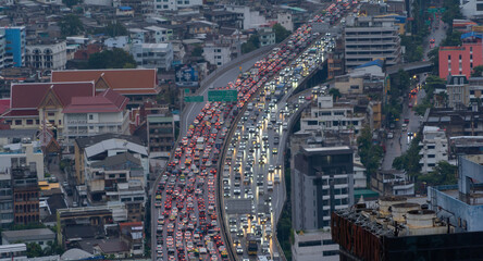 Fototapeta premium Aerial view of busy cars with traffic jam in the rush hour on highway road street on bridge in Bangkok Downtown, urban city in Asia, Thailand at sunset. Intersection junction. Toll gate in Rama 9