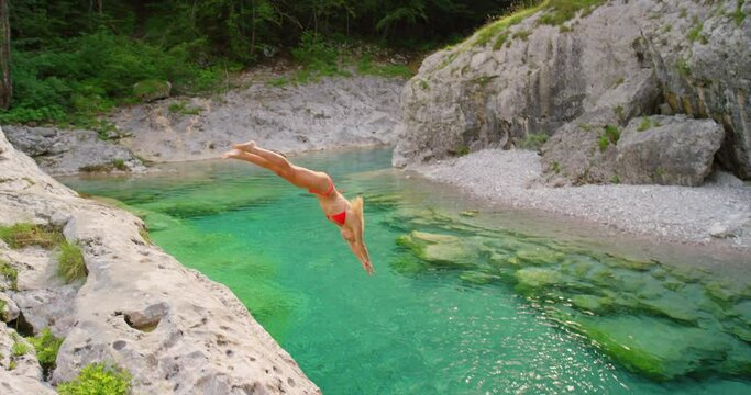 Dive, water and summer with a woman in a bikini jumping into a lake outdoor while on vacation or holiday. Swimming, nature and tropical with an attractive young female diving into a river for freedom