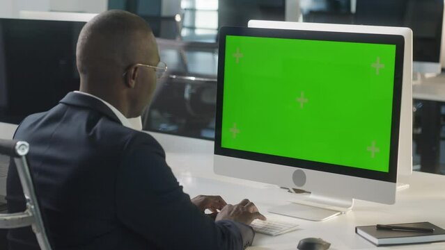 Business African-American Man Hands Working Internet on Computer On Desk. Girl Surfing on PC with Green Screen Notebook. Close Up Male Freelancer Searches For Information on The Internet