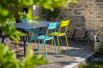 Chaise de jardin sur une terrasse en bois au soleil en été.
