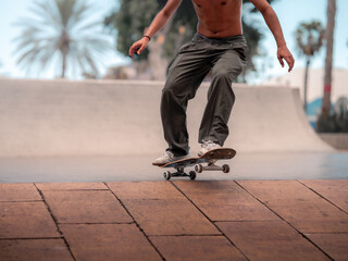 young skateboarder jumping with his board in a skate park. close up
