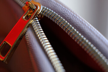 Selective focus, yellow metal zipper of a makeup bag or small purse macro pattern background