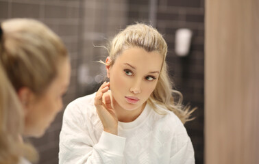 Woman looking in the mirror Applying the cream..Magic anti-aging cream