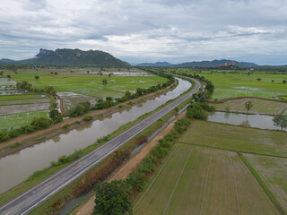 Aerial top view of road or street on mountain hill with green natural forest trees in rural area of Thailand. Transportation.