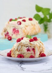 Baked meringue roll with cream and fresh red raspberry, white background.