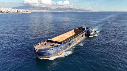 Aerial drone photo of assisted with tug boat empty barge boat cruising in deep blue sea - obrazy, fototapety, plakaty