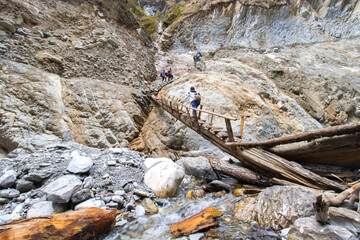 Dangerous roads in the Himalayas. A girl crossing dangerous bridge Adventure in the mountains