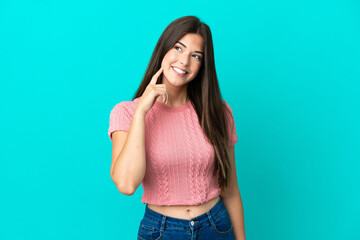 Young Brazilian woman isolated on blue background thinking an idea while looking up