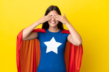 Super Hero Brazilian woman isolated on yellow background covering eyes by hands