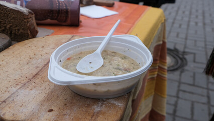 Social food, porridge in a disposable plastic plate, on the street in Ukraine