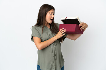 Fototapeta premium Young Brazilian woman isolated on white background pregnant and holding a gift with surprised expression