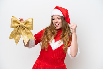 Young caucasian woman with Christmas dress holding Christmas bow isolated on white background celebrating a victory