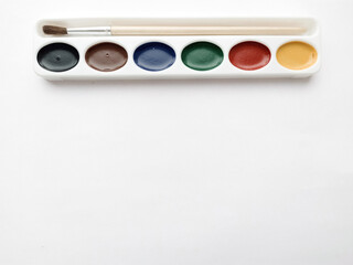 Brush and paint on a white background. Everything for drawing. Creation. Children is creativity. Hobby. Colored paints and gouache.