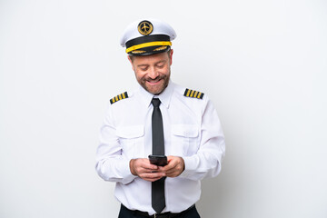 Airplane middle age pilot isolated on white background sending a message with the mobile