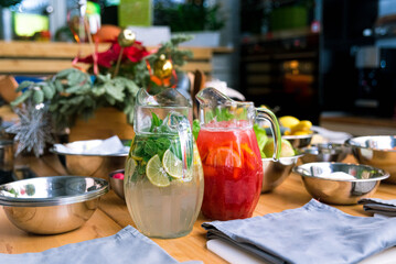 Soft drinks lemonades in large glass jugs on the kitchen table