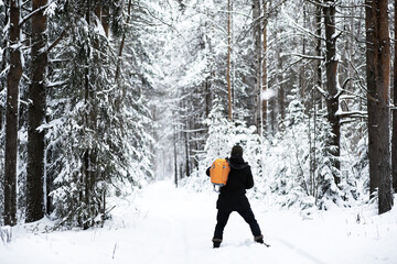 A man with a backpack travels in winter. A man in a snowy field. Hiking winter landscape.