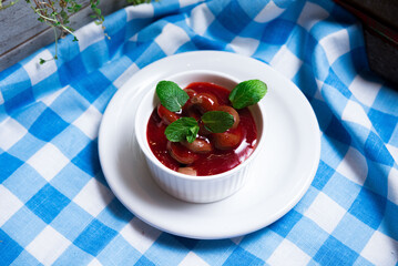 portion of chocolate mousse with berry coulis decorated with mint leaves
