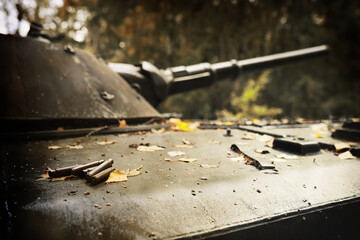 Toned photograph. A selective focus shot of an abandoned military tank in forest
